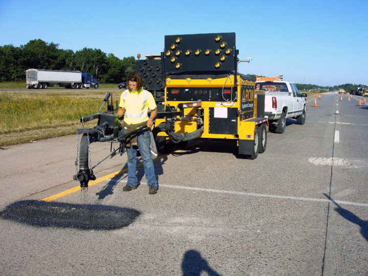 Schwarze Spray Patcher being used to repair a pothole
