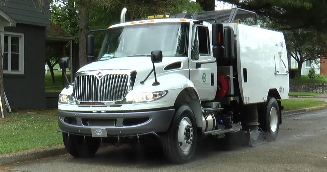 Schwarze Street Sweeper Sweeping Wet Roads