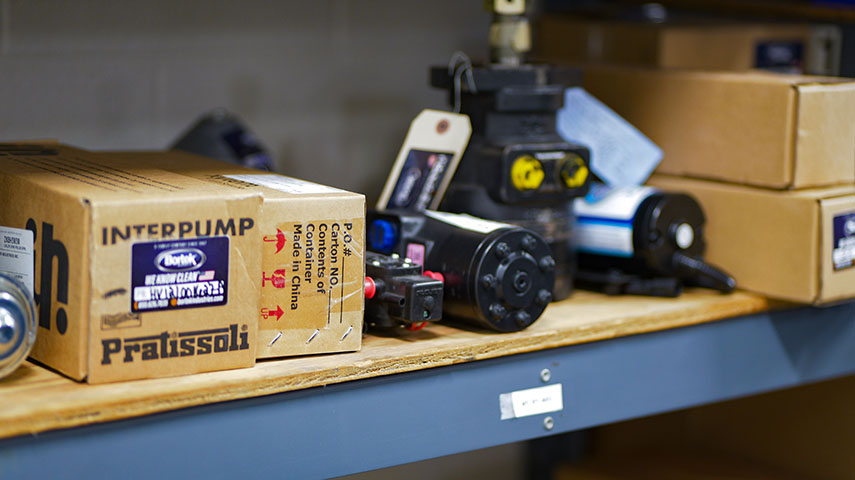 Various floor scrubber and sweeper parts on a shelf